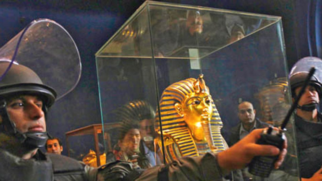 Egyptian Army special forces personnel stand guard beside a golden funerary mask of King Tutankhamun at the Egyptian Museum in Cairo