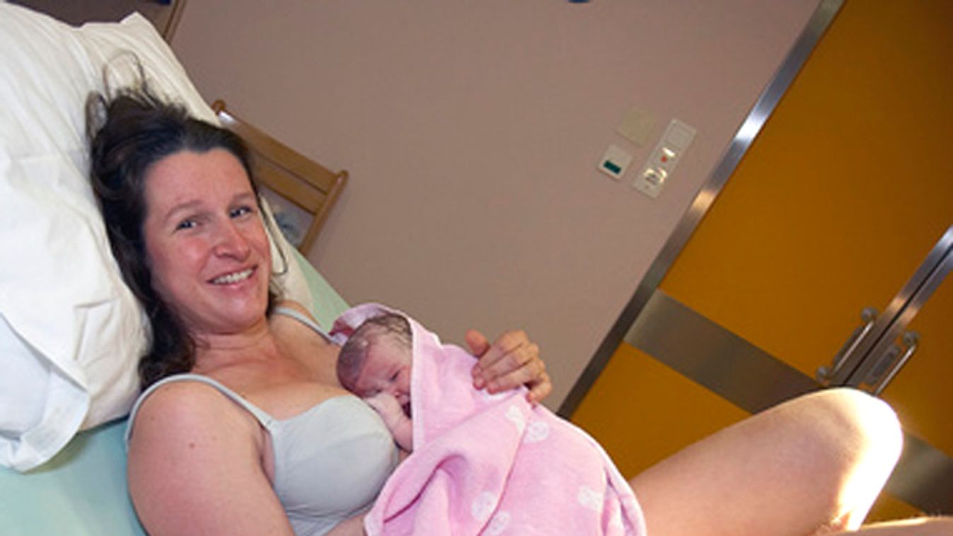 Mutter mit Neugeborenem im Kreissaal - nother with new born baby in maternity room