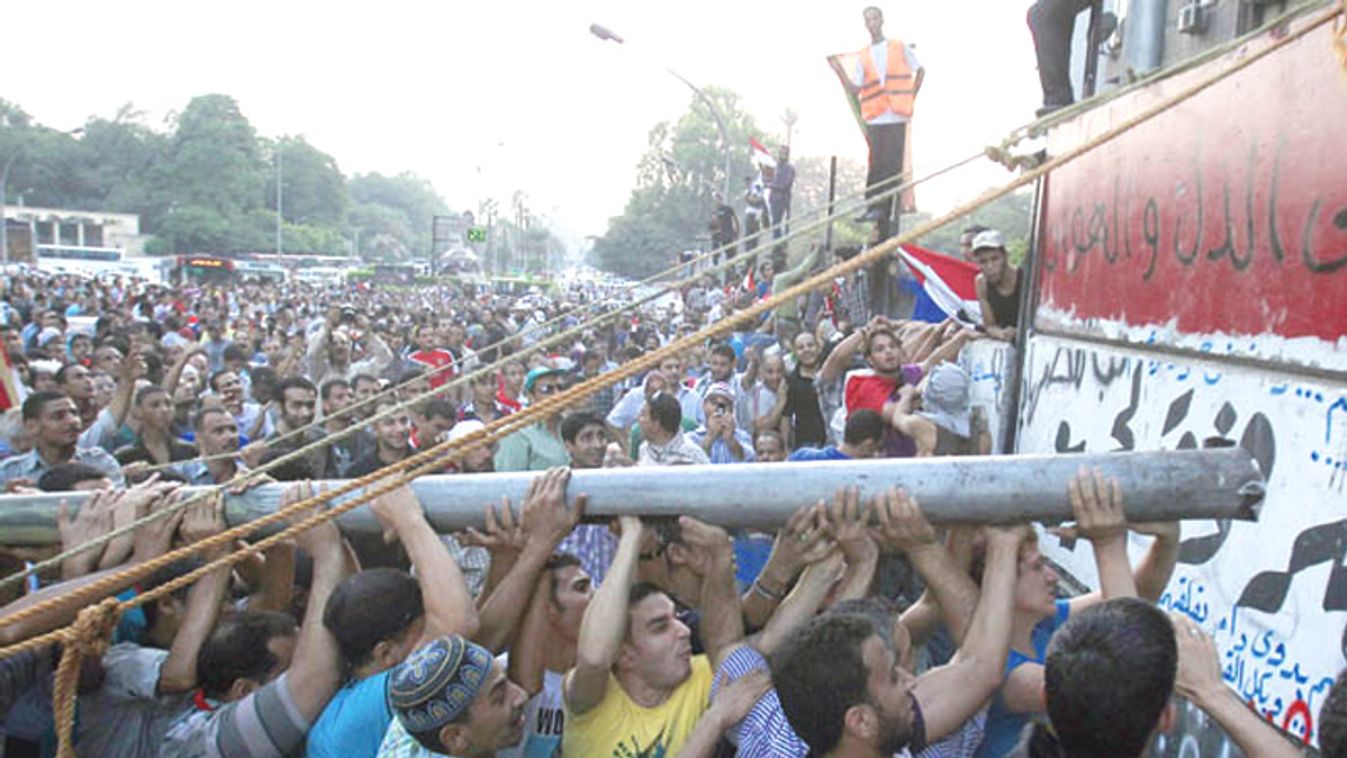 PProtesters tear down a concrete wall built in front of the Israeli embassy in Cairo