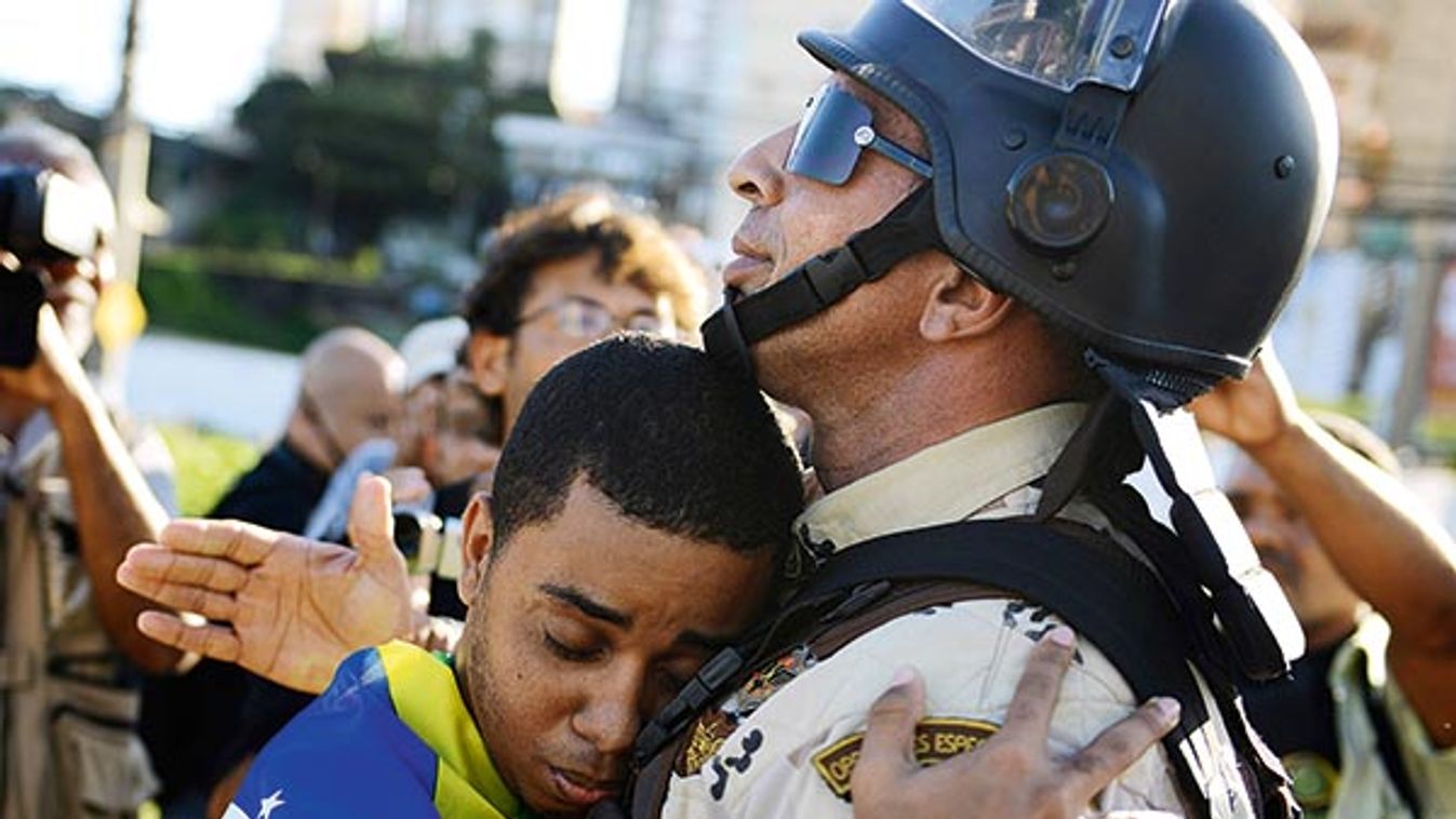 A demonstrator embraces a police commander in Salvador