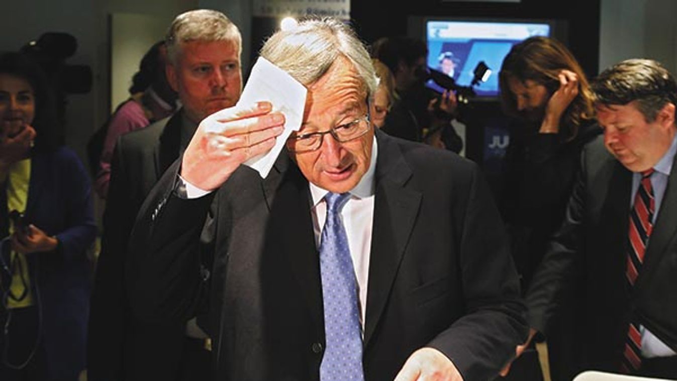 Candidate for the European Commission presidency Juncker wipes his forehead in Brussels