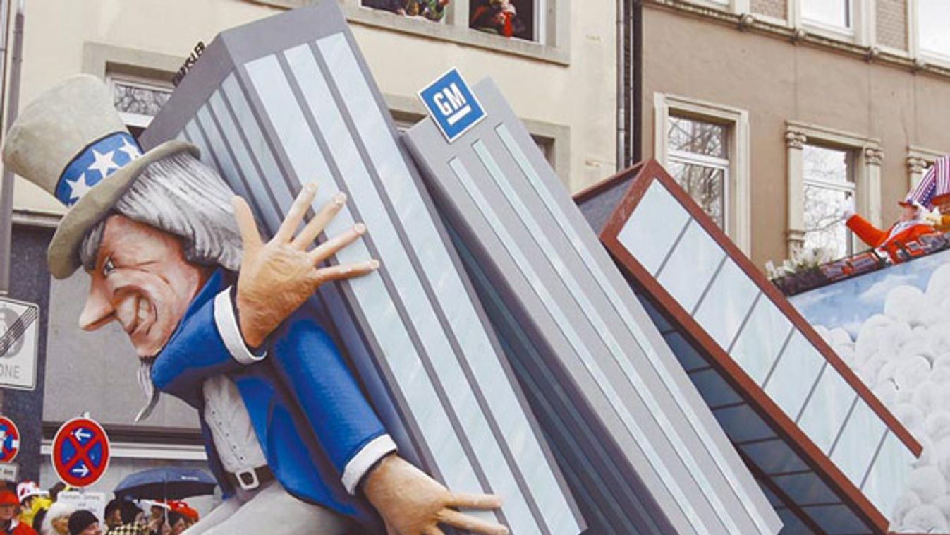 A carnival float shows a papier-mache figure representing Uncle Sam who is overwhelmed by crashing skyscrapers of the three US carmakers during the traditional Rose Monday carnival parade in Cologne