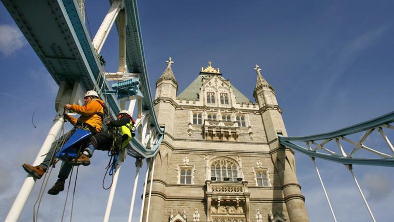 Two workers rig lights to Tower Bridge in preparation for "Switched on London" in London