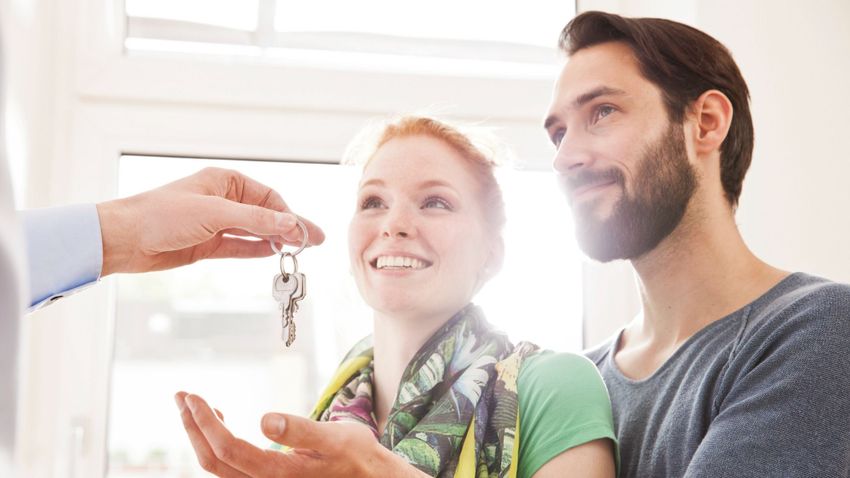 Young couple receiving house key from real estate agent