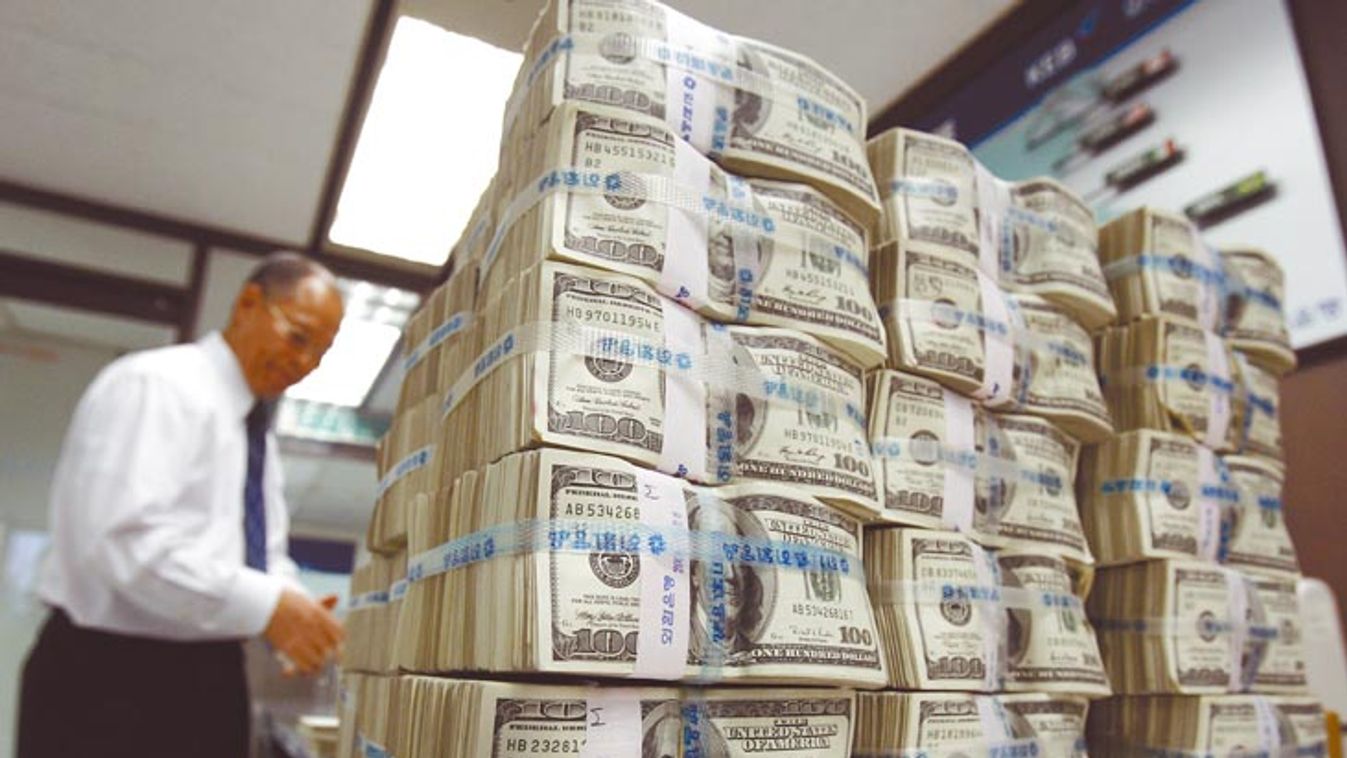 An employee of the Korea Exchange Bank counts 100-dollar bills for foreign bonds redemption at the bank's headquarters in Seoul