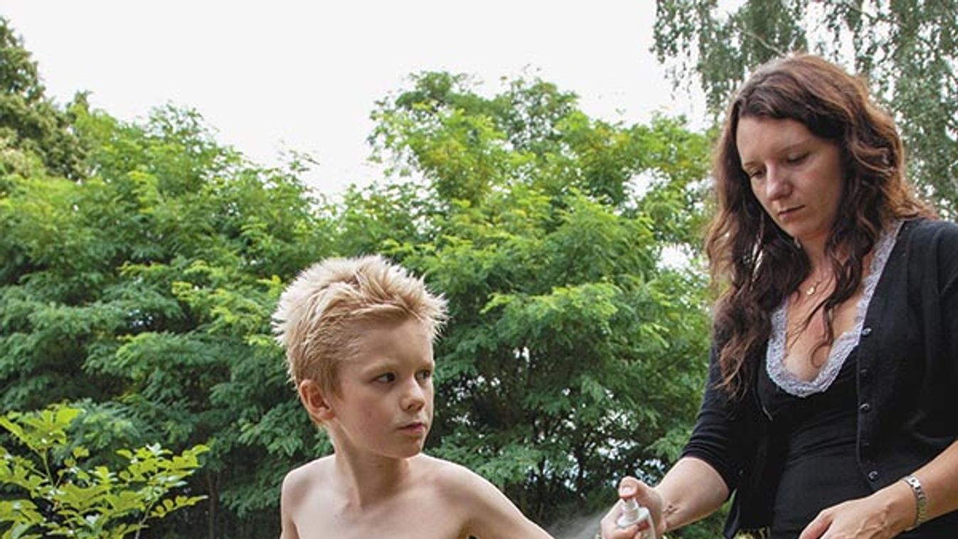 Boy age 8 being sprayed with mosquito repellent by his mother age 8 and 32. Zawady Central Poland