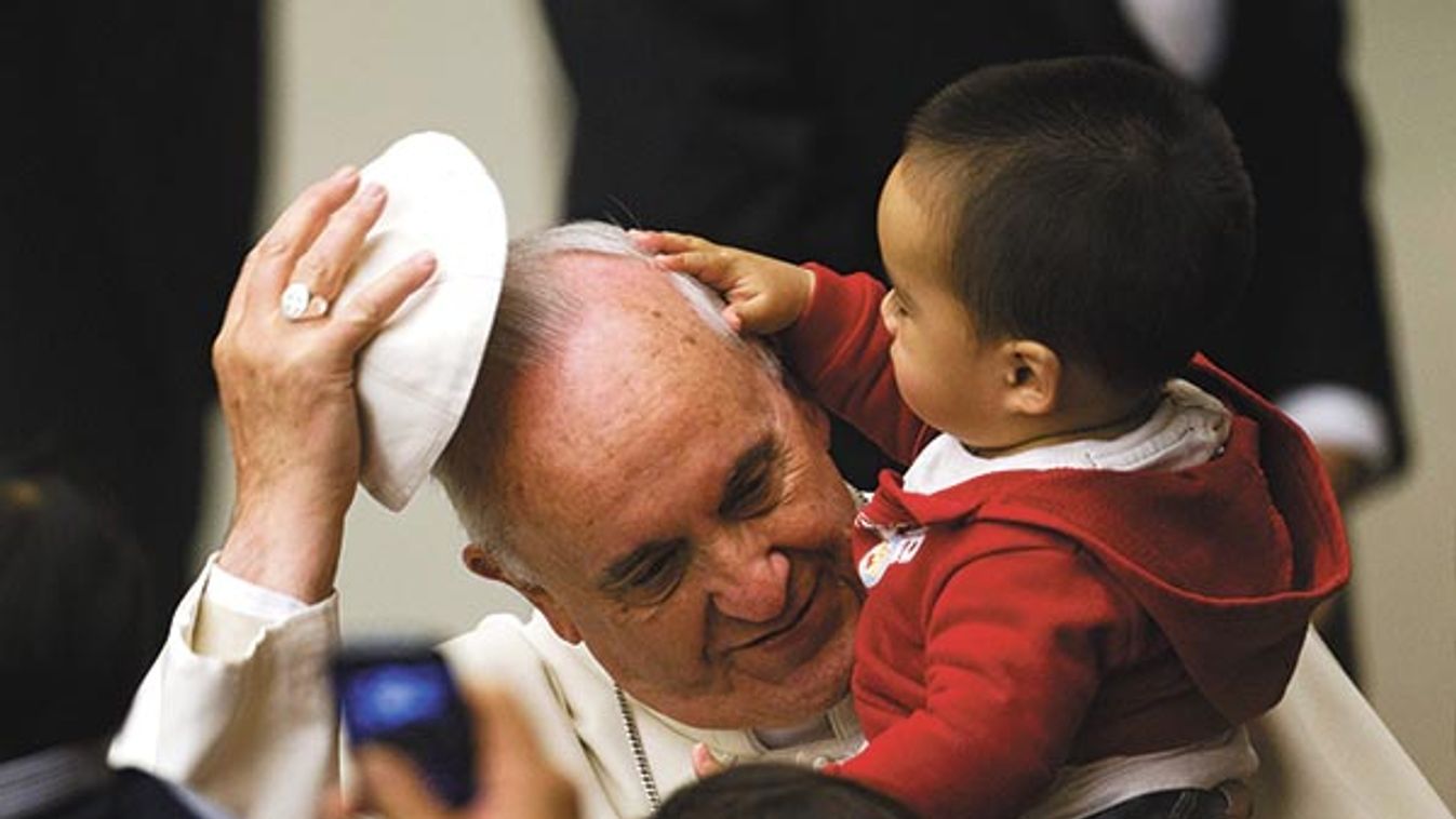 Pope Francis has his skull cap removed by a child during an audience with children in the Vatican