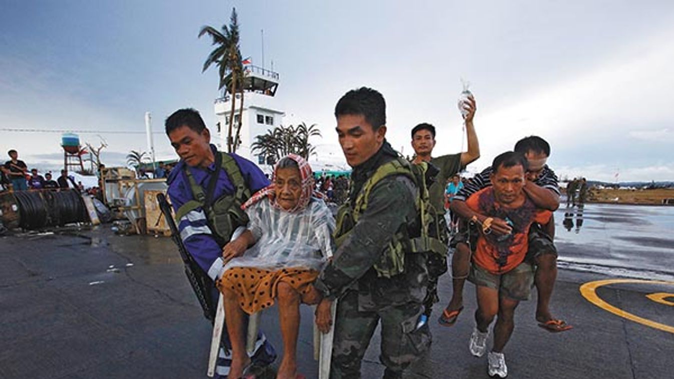 Filipino soldiers bring Tacloban residents onto a military plane leaving Tacloban airport in central Philippines