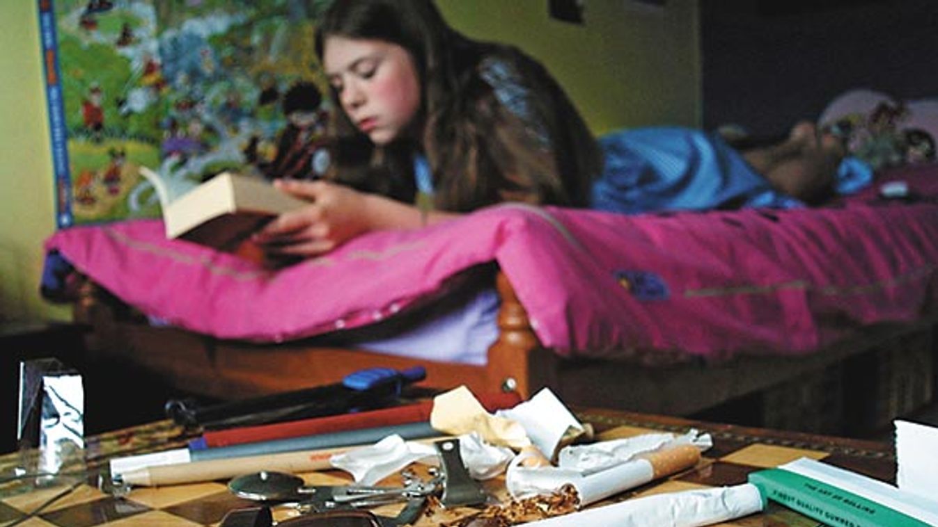 School girl reading in her bedroom, cannabis and drug paraphernalia on the bed side table.