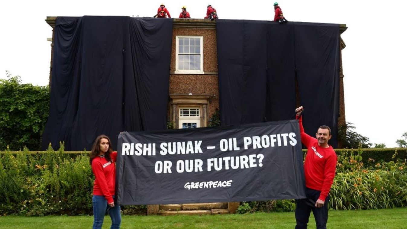 A handout picture taken and released by environmental action group Greenpeace on August 3, 2023 shows Greenpeace activists on the roof of Britain's Prime Minister Rishi Sunak's manor house in Kirby Sigston, northern England, to protest at his backing for new oil and gas licences in the North Sea.