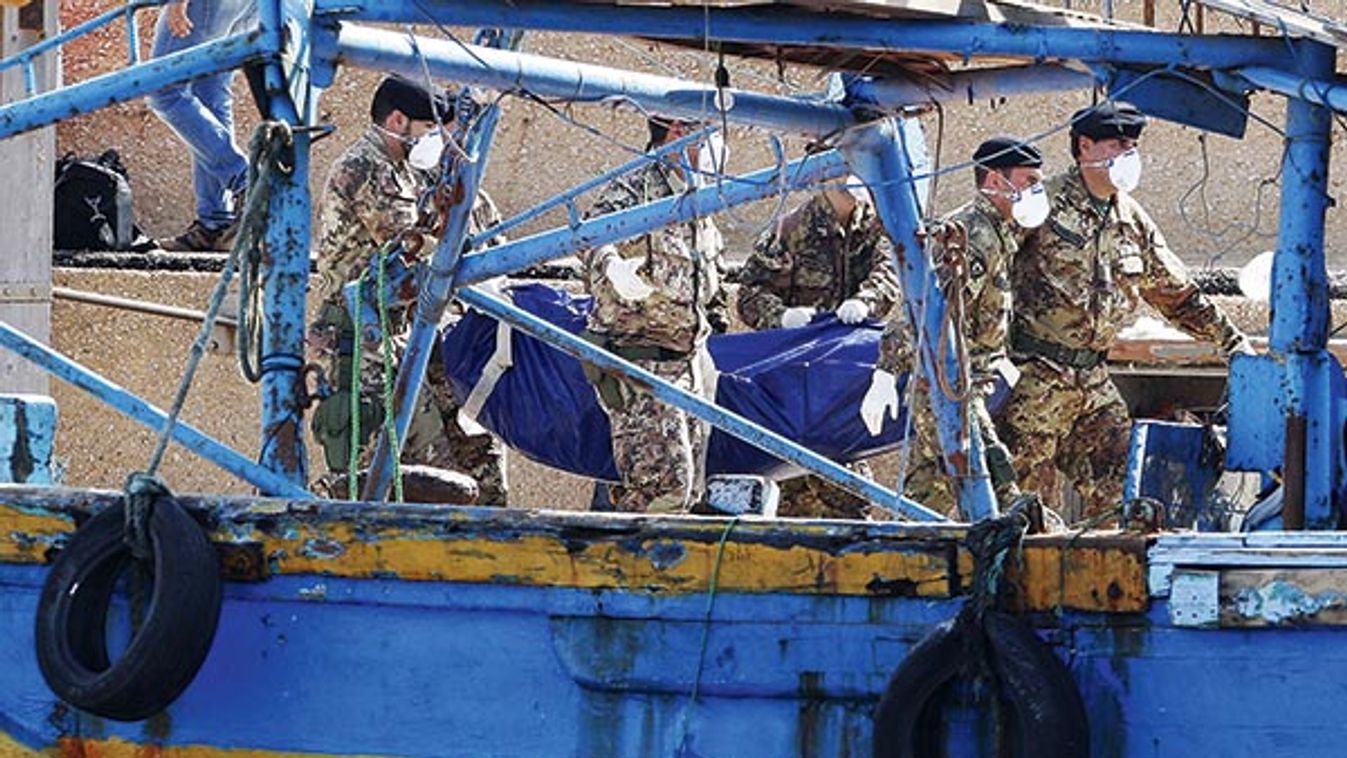 Soldiers carry the body of a victim of a shipwreck off Sicily in Lampedusa harbor