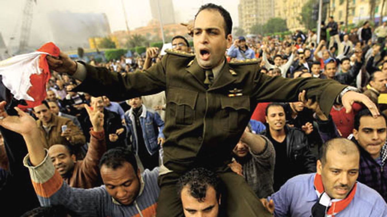 An Egyptian Army officer shouts slogans as he is carried by protesters in Cairo