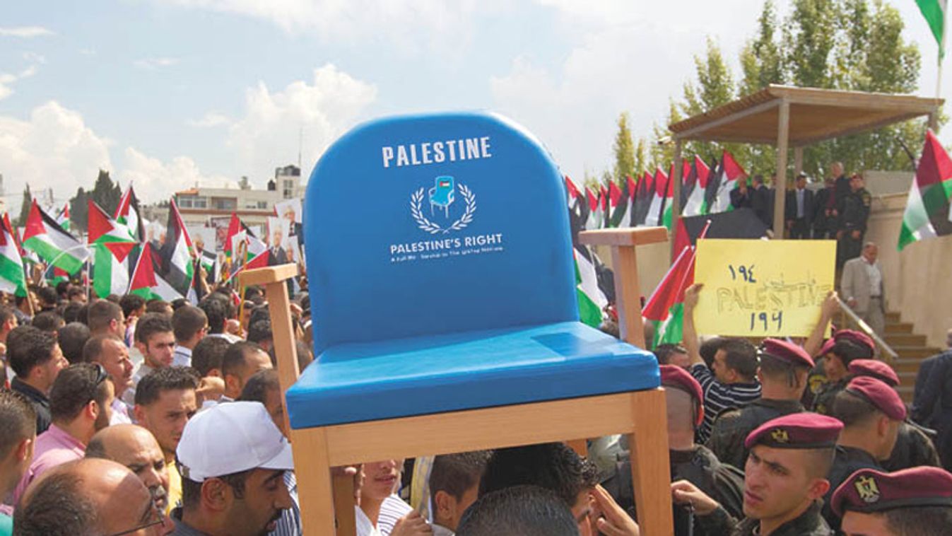 Palestinians carry a chair representing their seat at the U.N. during a rally in  in Ramallah upon Abbas' return from the U.S.
