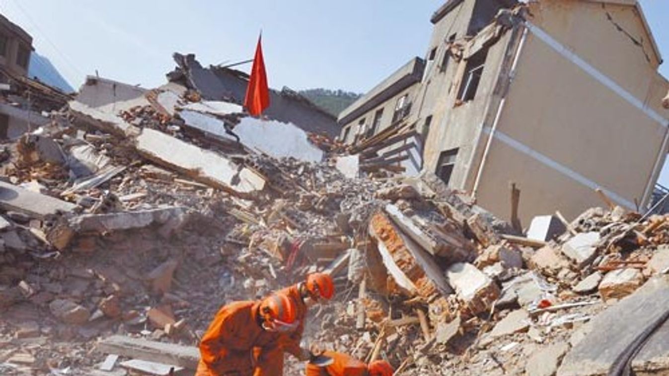 Rescue workers rummage through the rubble of a collapsed building in Nanba