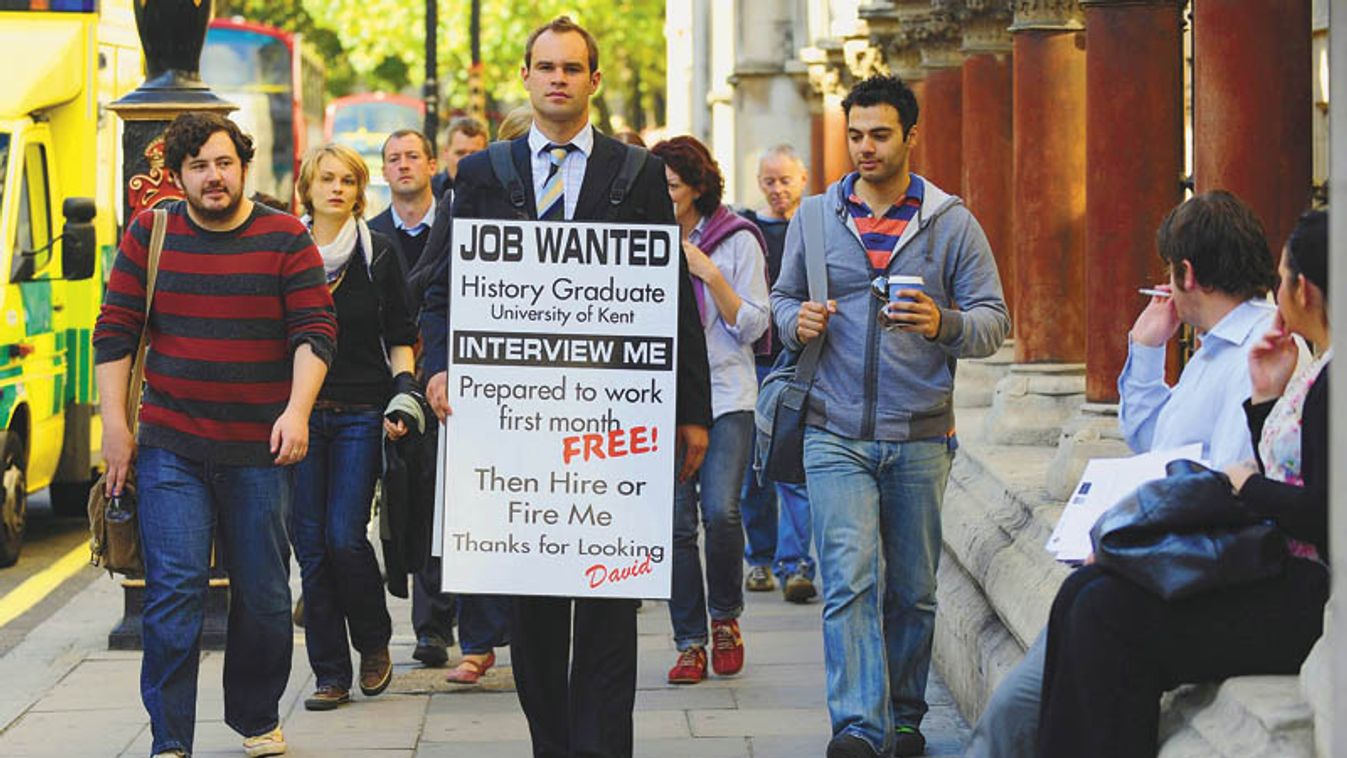 Jobless Rowe wears a sandwich board advertising his search for employment as he walks along Fleet Street in central London