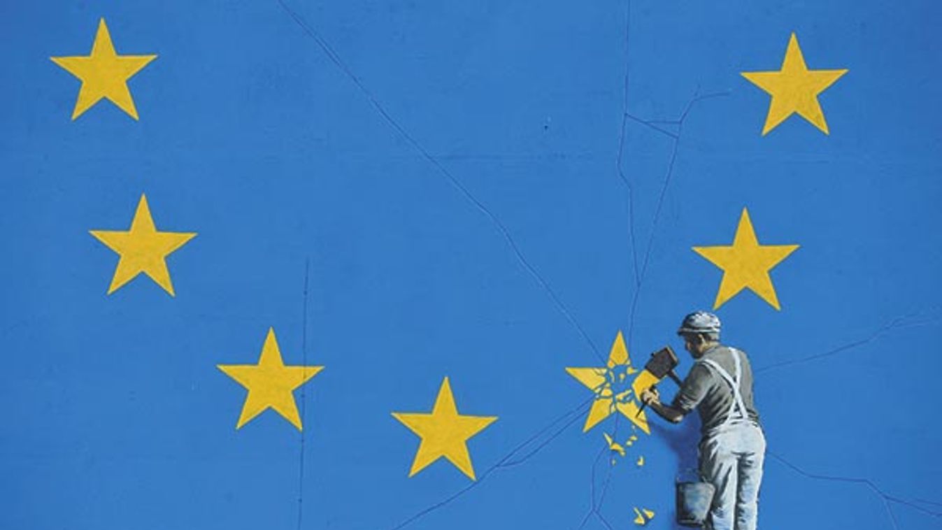 A section of an artwork attributed to street artist Banksy, depicting a workman chipping away at one of the 12 stars on the flag of the European Union, is seen on a wall in the ferry  port of Dover