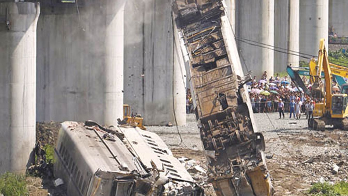 A derailed carriage of a bullet train is removed from a bridge as workers dig through the wreckage after a high speed train crashed into a stalled train in Wenzhou