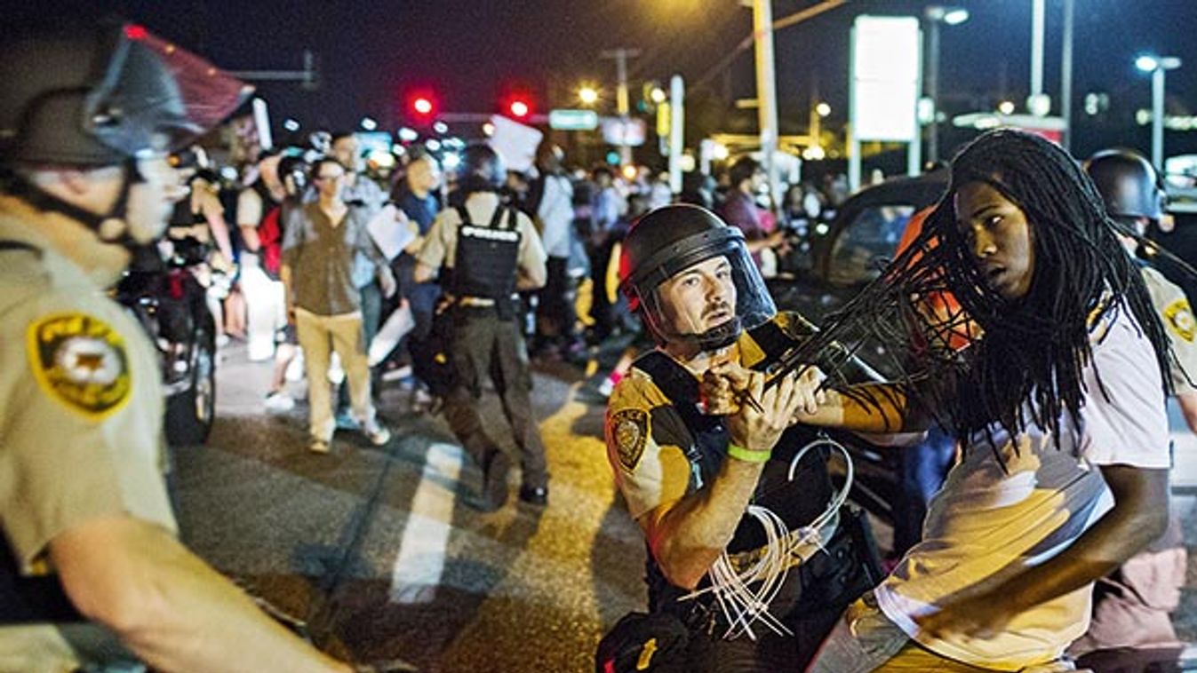 St Louis County police officers hold an anti-police demonstrator in Ferguson, Missouri