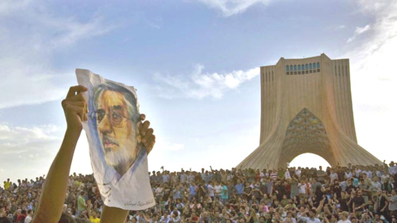 A demonstrator shows a picture of former presidential candidate Mousavi during a rally in support of Mousavi near Azadi monument, western Tehran