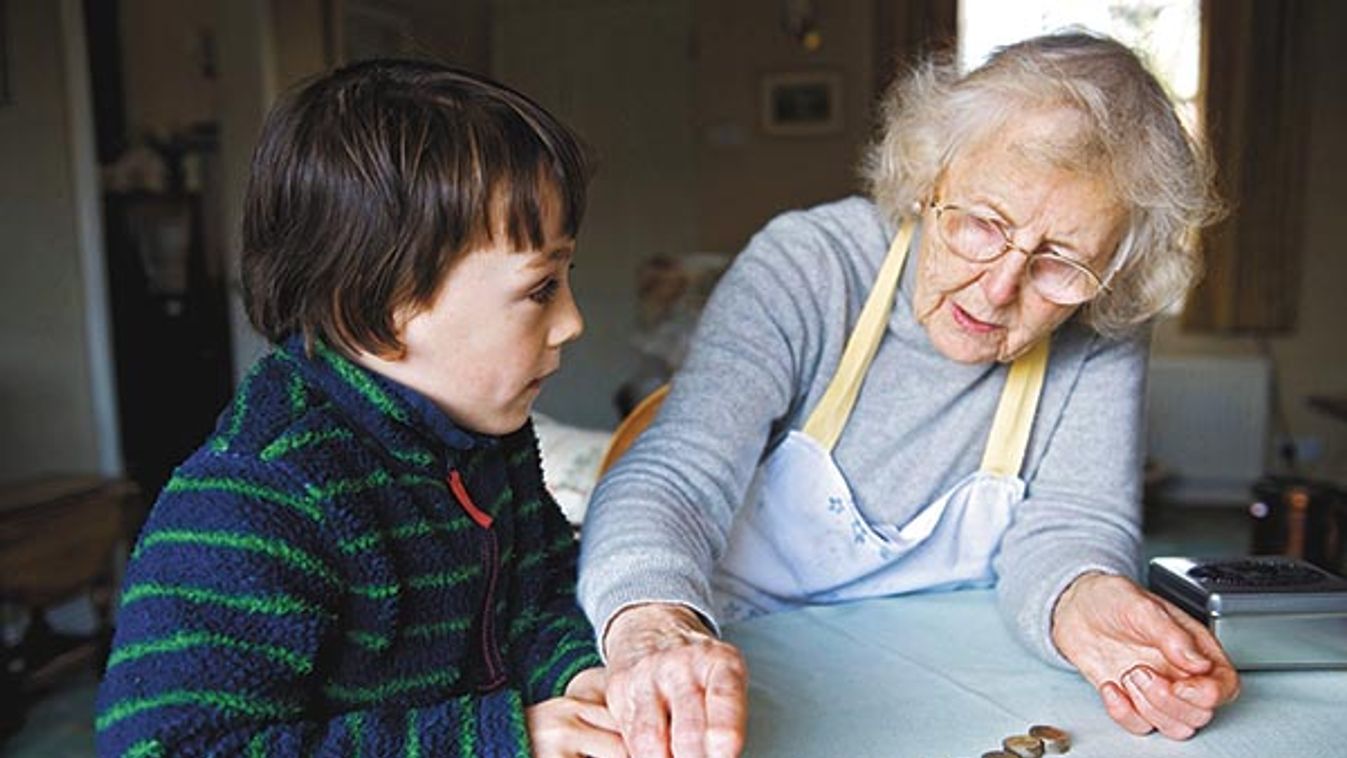 grandma and grandson counting coins at dining table