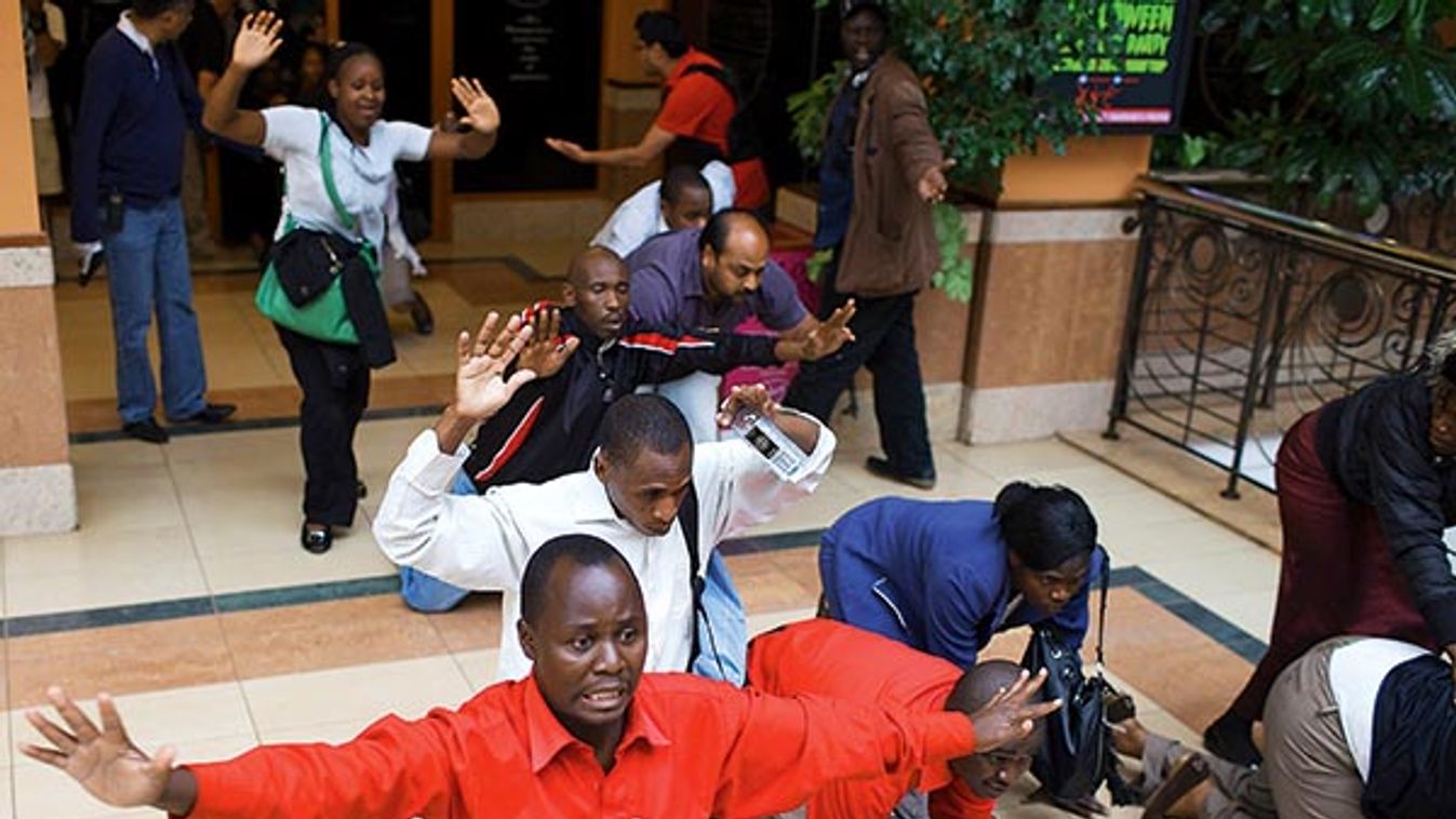 People raise their hands while armed police officers search for gunmen at Westgate mall in Nairobi, Kenya.