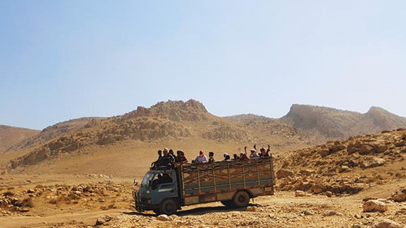 Displaced people from the Yazidi religious minority ride on a truck as they are evacuated from Mount Sinjar