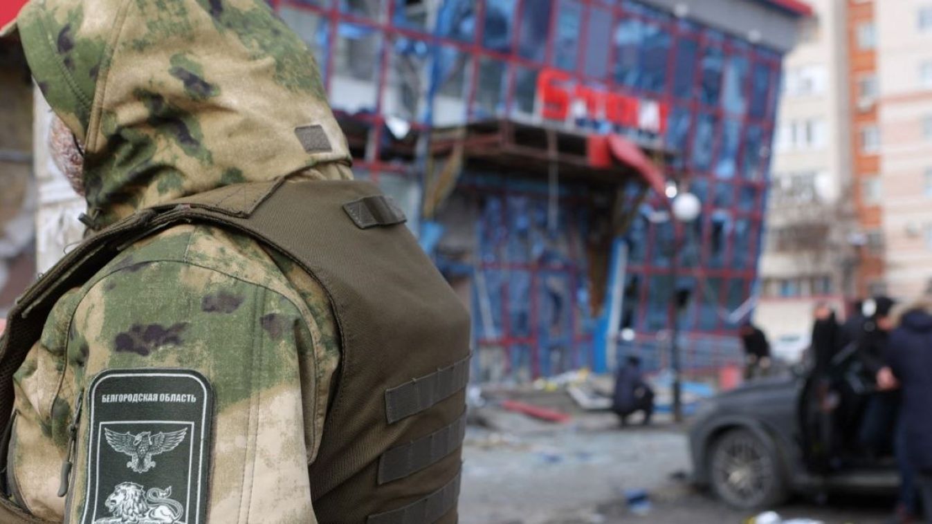 A person wearing a camouflage outfit is seen by a damaged shopping centre following an air attack on Belgorod on February 15, 2024. At least six people were killed a dozen wounded on February 15, 2024 after a Ukrainian rocket strike on the city of Belgorod, officials said.