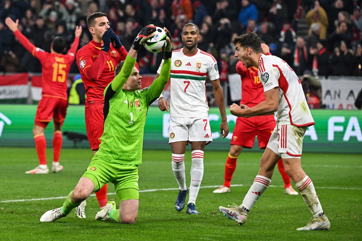 Hungary's defender #05 Botond Balogh (R) celebrates with Hungary's goalkeeper #01 Denes Dibusz after he made a save during the UEFA Euro 2024 group G qualification football match between Hungary and Montenegro in Budapest on November 19, 2023. (Photo by Attila KISBENEDEK / AFP)