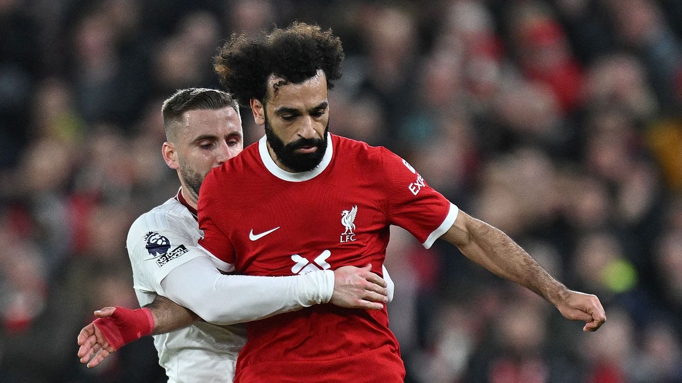 Manchester United's English defender #23 Luke Shaw (C) vies with Liverpool's Egyptian striker #11 Mohamed Salah during the English Premier League football match between Liverpool and Manchester United at Anfield in Liverpool, north west England on December 17, 2023. (Photo by Paul ELLIS / AFP)