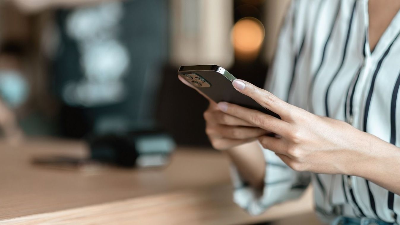 Close,Up,Hand,Of,Woman,Using,Smartphone,At,Coffee,Shop