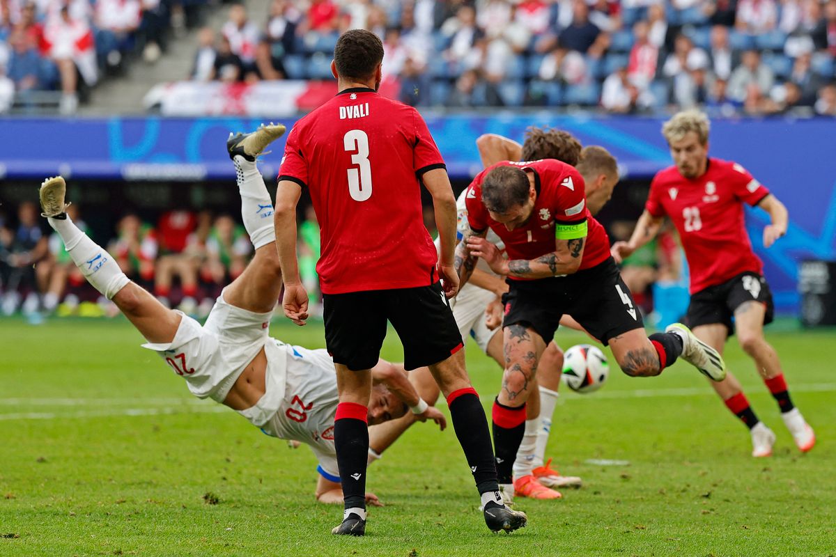 Czech Republic's midfielder #20 Ondrej Lingr (L) falls as Georgia's defender #04 Guram Kashia (R) fights for the ball during the UEFA Euro 2024 Group F football match between Georgia and the Czech Republic at the Volksparkstadion in Hamburg on June 22, 2024.