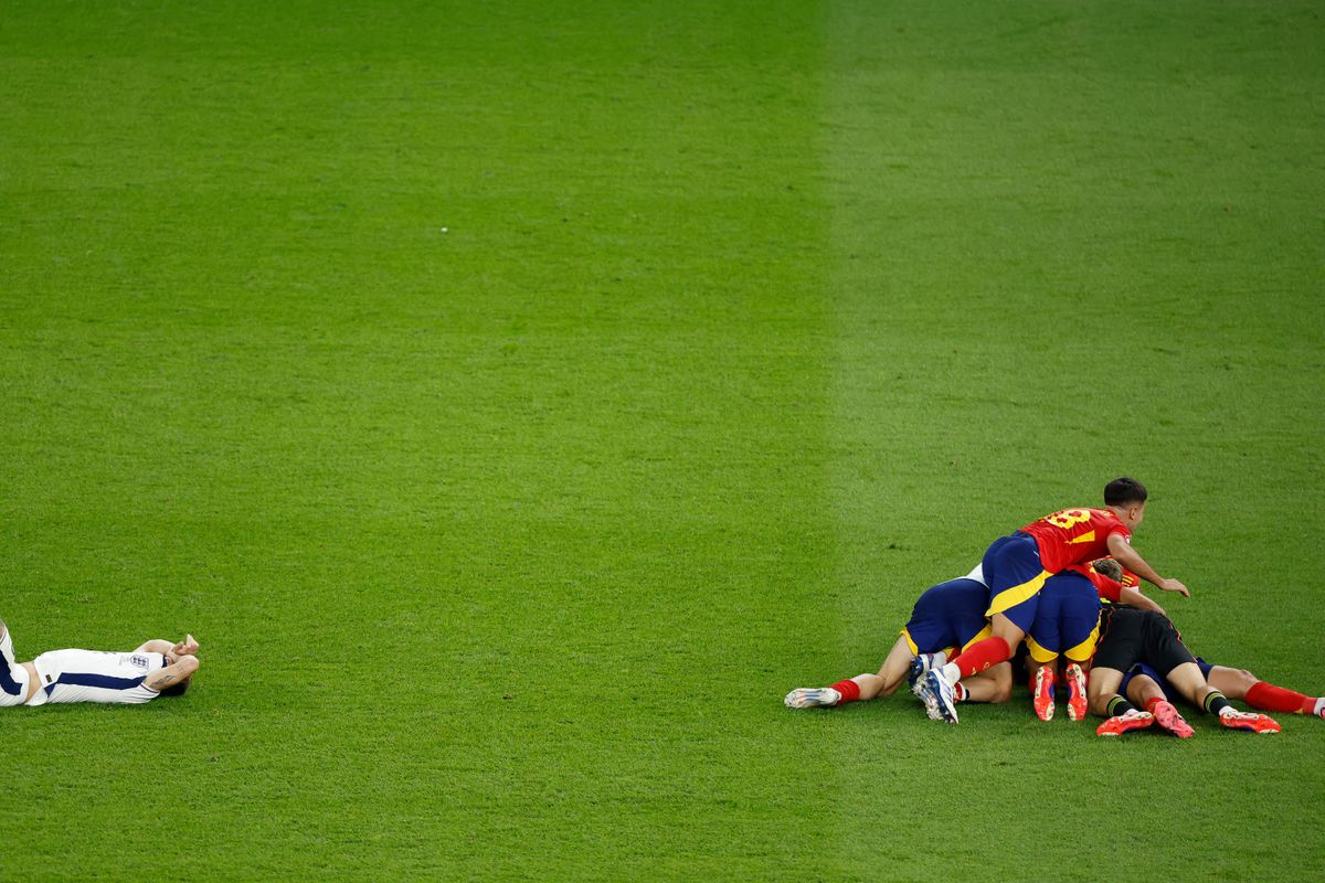 England's defender #05 John Stones reacts as Spain's players celebrate winning the UEFA Euro 2024 final football match between Spain and England at the Olympiastadion in Berlin on July 14, 2024. 