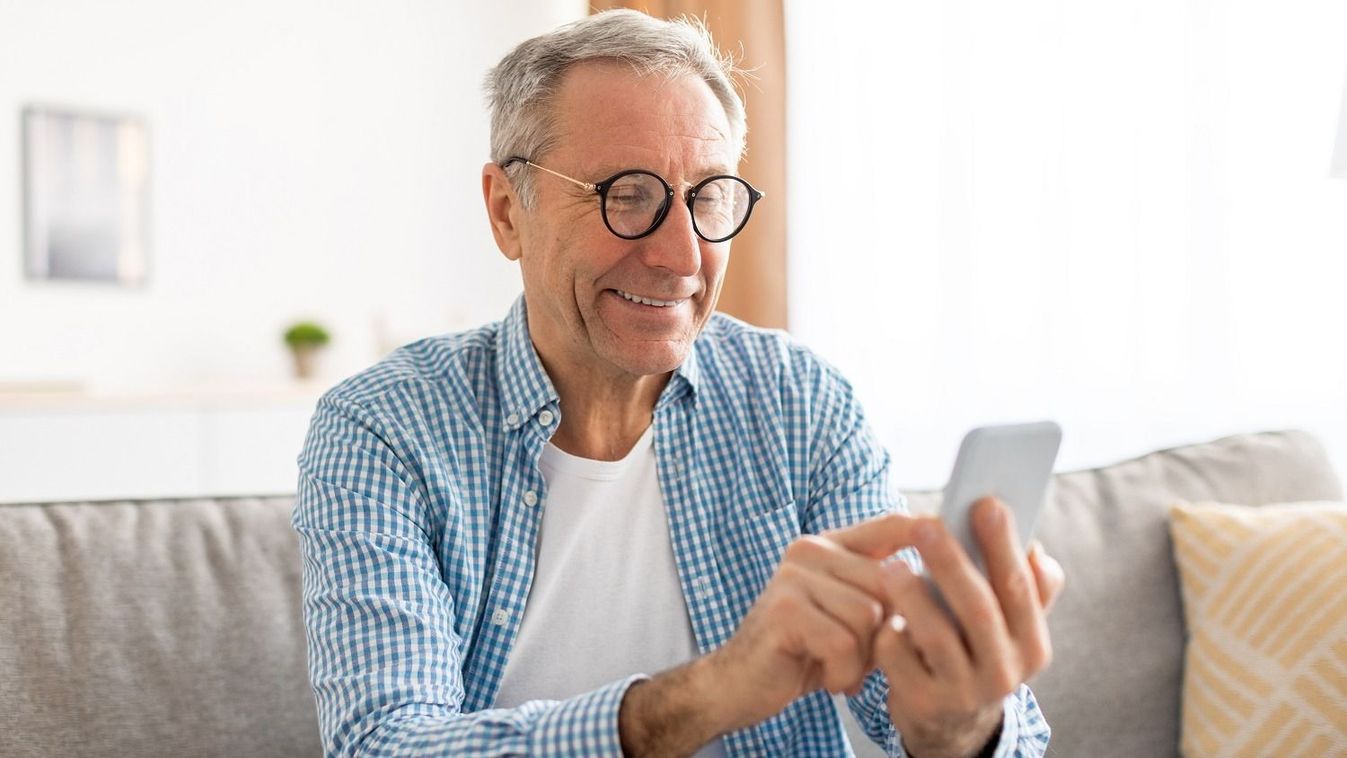 Portrait,Of,Cheerful,Mature,Guy,In,Glasses,Using,Mobile,Phone