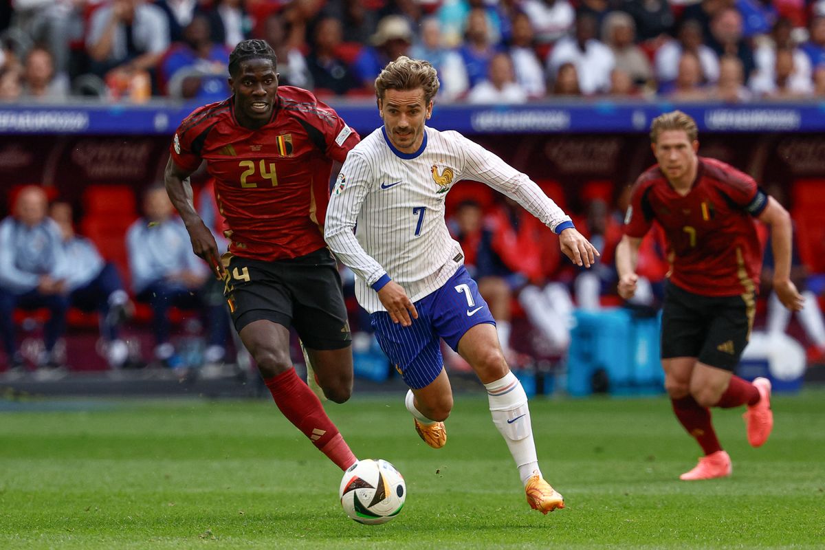 France's midfielder #07 Antoine Griezmann runs with the ball flanked by Belgium's midfielder #24 Amadou Onana (L) during the UEFA Euro 2024 round of 16 football match between France and Belgium at the Duesseldorf Arena in Duesseldorf on July 1, 2024. 