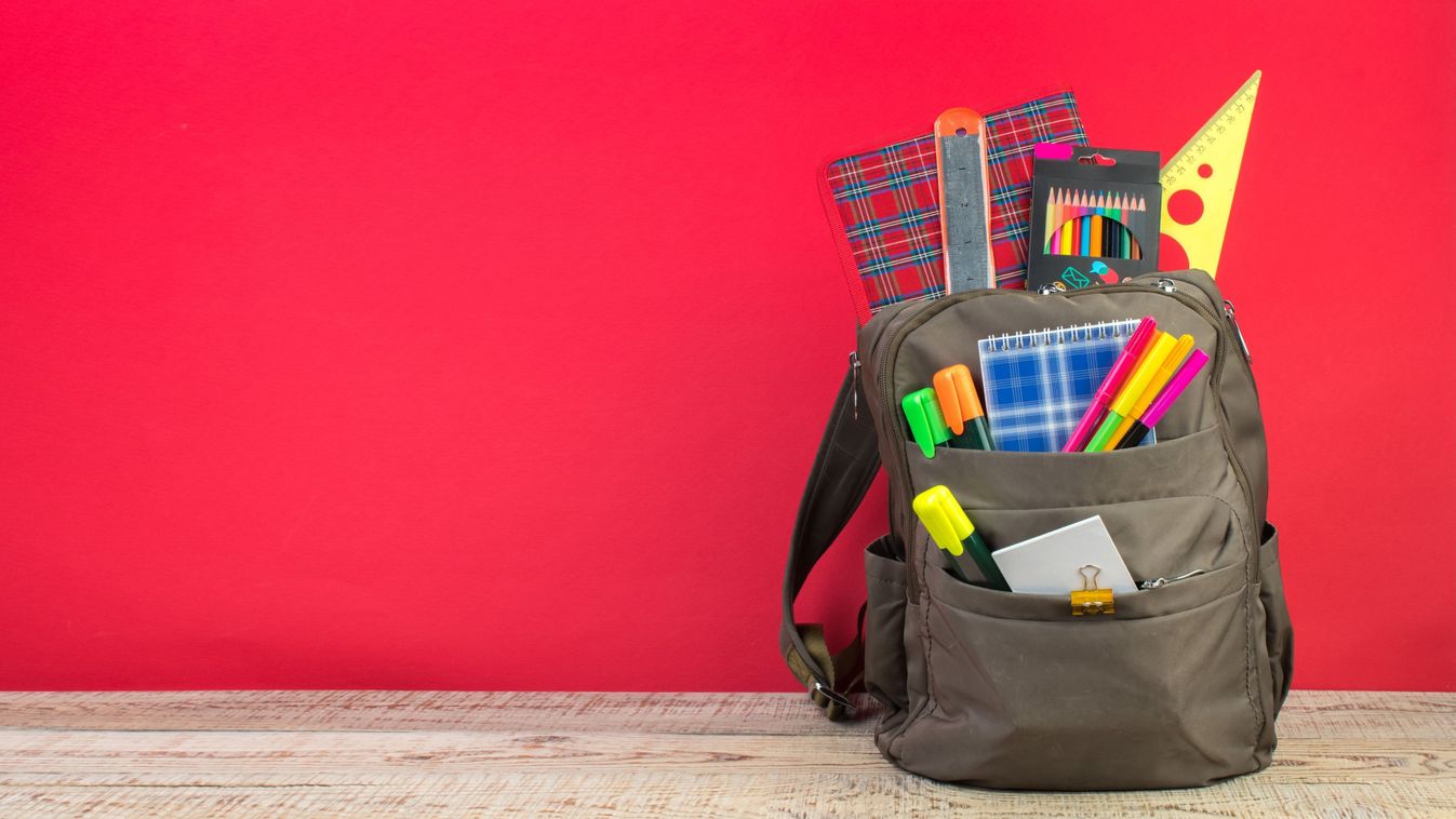 Backpack,With,Different,Colorful,Stationery,On,Table.,Bright,Red,Background.