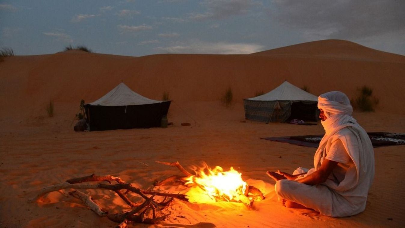 Mauritanian travel guide making fire at night at a camp in the desert.. Chinguetti. Ancient ksour of Ouadane, Chinguetti, Tichitt and Oualata. Adrar. Mauritania