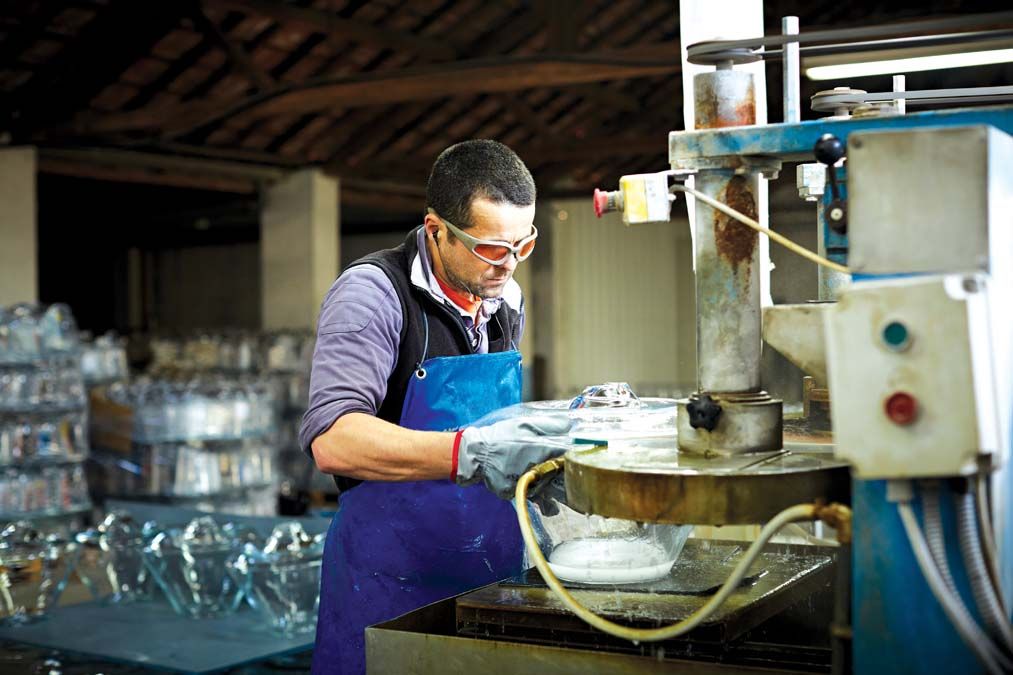 Male worker trimming excess glass