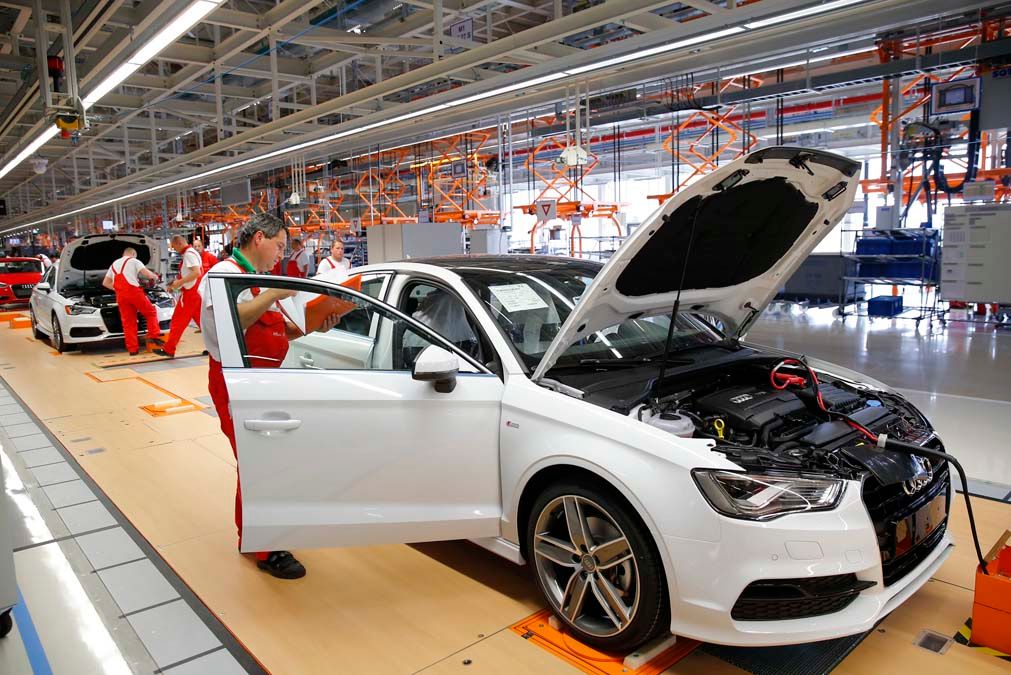 Factory workers make checks on cars on the assembly line during the launch of a new factory of German premium car maker Audi in Gyor