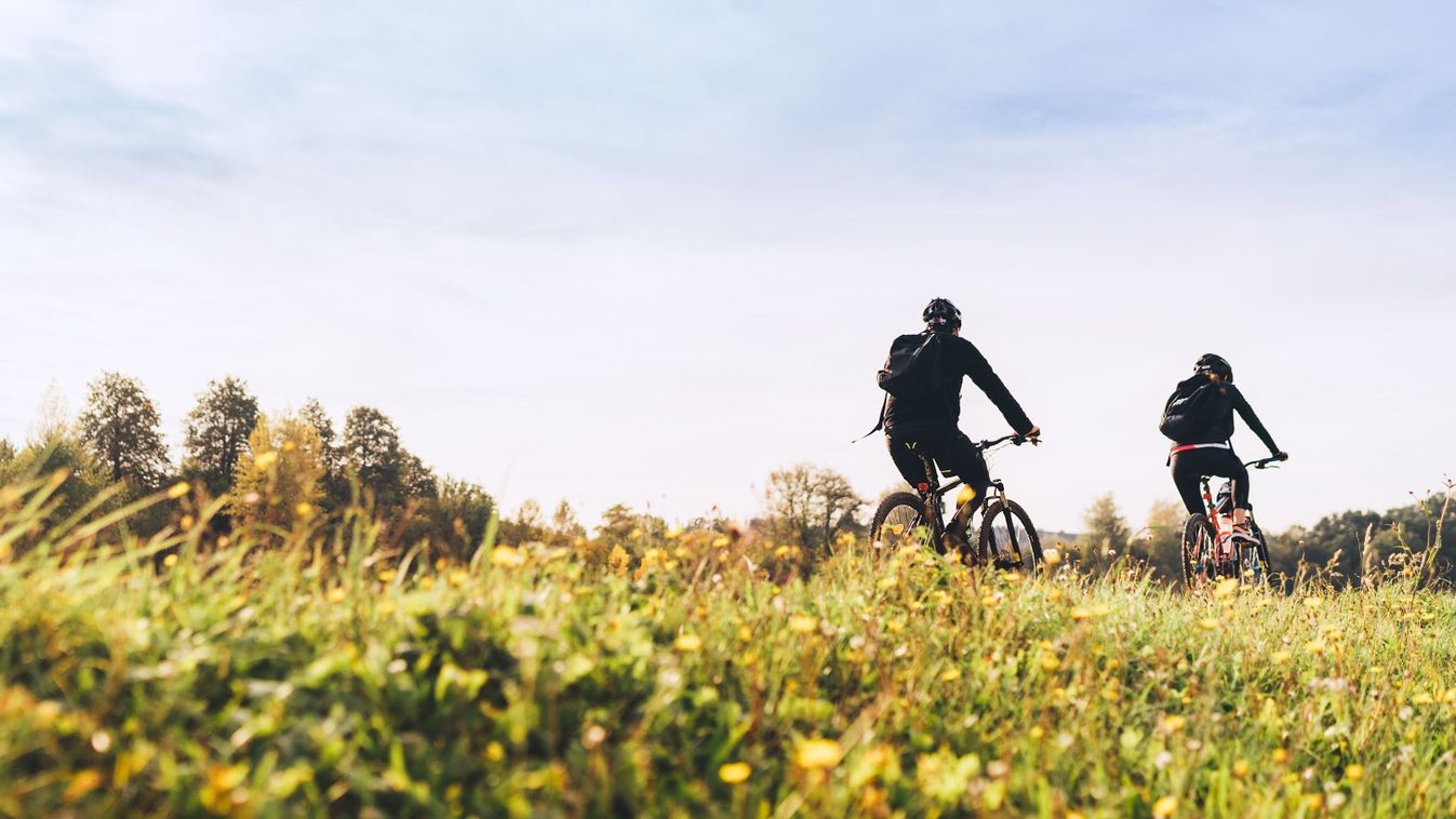 Young,Couple,Man,And,Woman,Bicyclists,With,Backpacks,Riding,Under