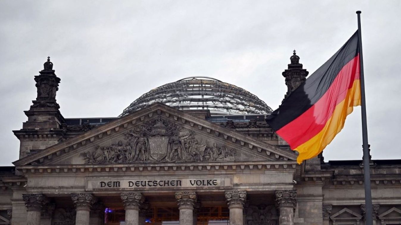 View of the Reichstag building with a waving German flag. The Reichstag building on Platz der Republik in Berlin is the seat of the German Bundestag.