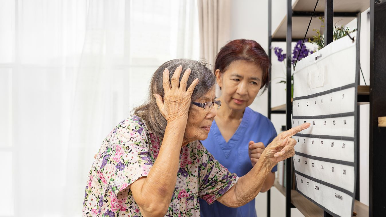 Confused,Asian,Elderly,Woman,With,Dementia,Looking,At,Wall,Calendar.