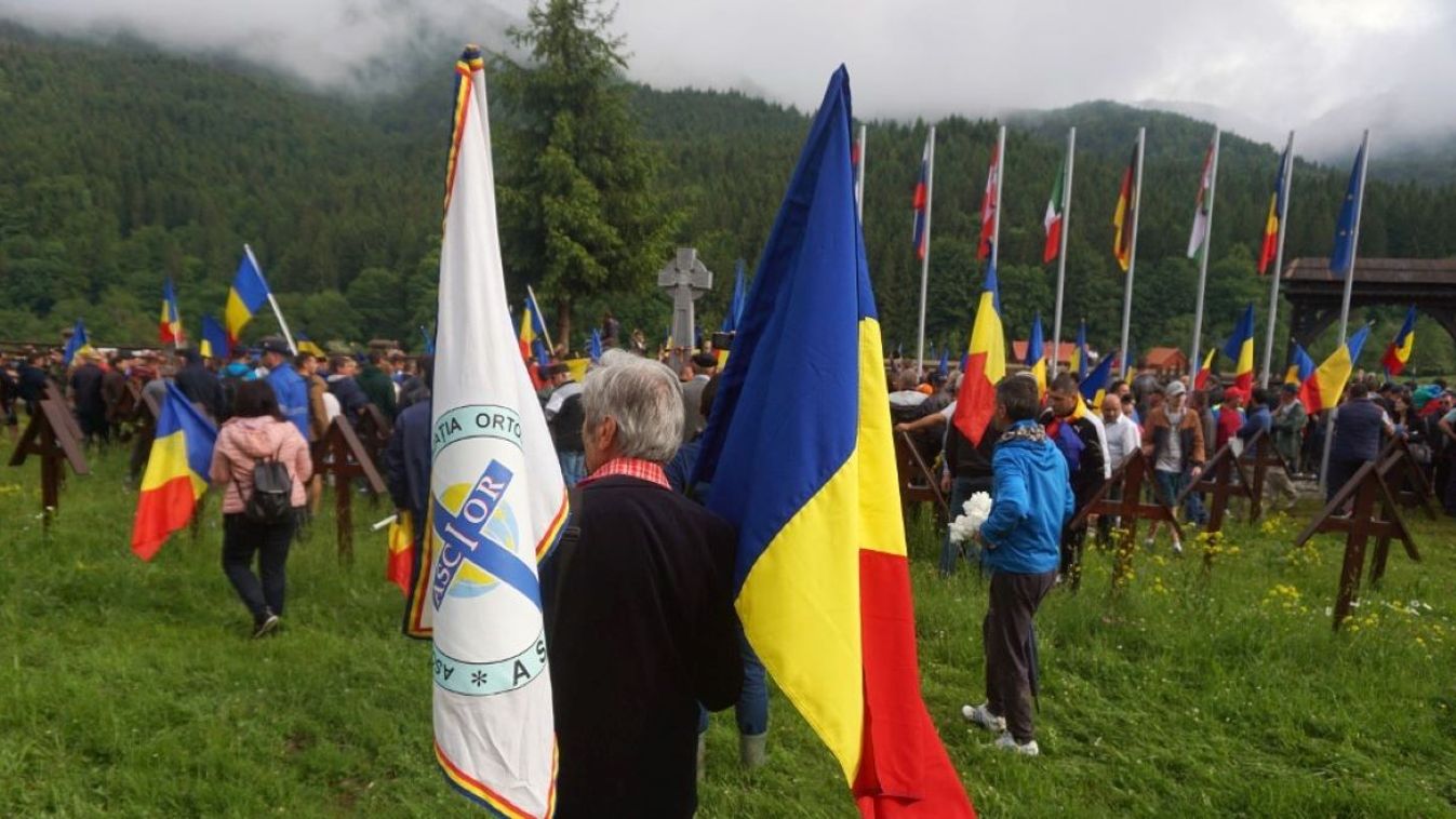 Romanian nationalist carry a national and orthodox brotherhood flag as they forced entrance to the military cemetery in the village of Valea Uzului, Romania on June 6, 2019.