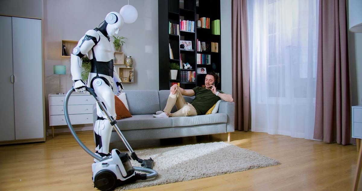 Robot,Humanoid,Cleaning,Room,With,Vacuum,Cleaner,While,Man,Sitting