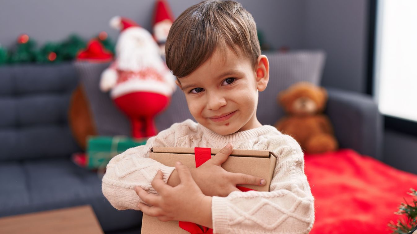 Adorable,Hispanic,Boy,Hugging,Christmas,Gift,Standing,At,Home