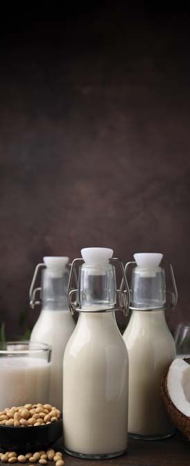 Different,Types,Of,Vegan,Milk,And,Ingredients,On,Wooden,Table