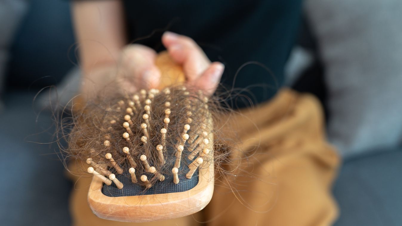 Cropped shot of woman hand holding comb with messy hair loss after brushing her hair.