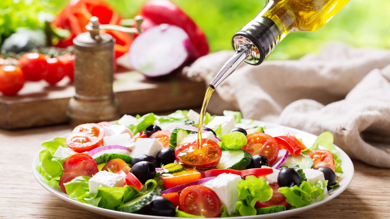 Olive,Oil,Pouring,Into,Plate,Of,Fresh,Greek,Salad,With