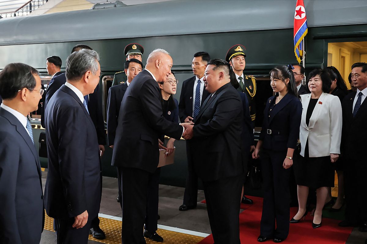 Kínai tisztviselők fogadják Kim Dszongunt, Észak-Korea vezetőjét. Mögötte áll a lánya, akit sokan már a kiválasztott örökösnek tekintenek. Fotó: KCNA VIA KNS 