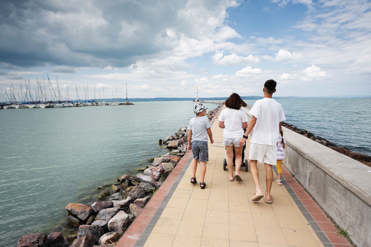 Family,Walking,Together,On,A,Pier,By,The,Water,With