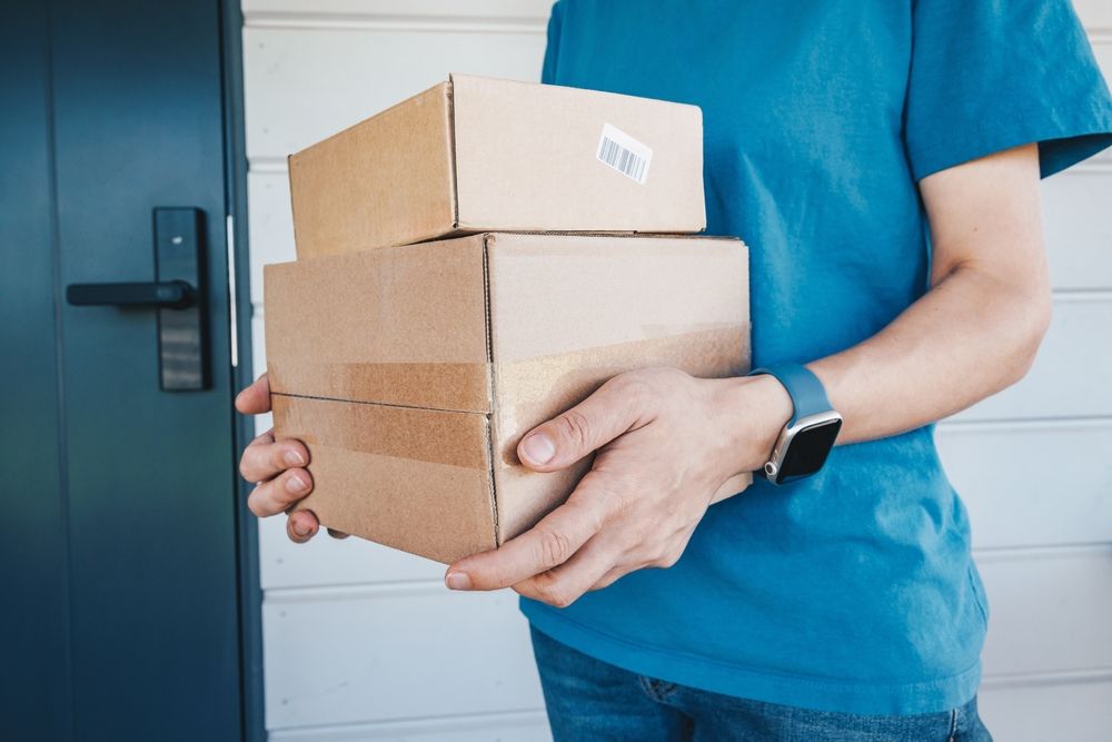 A,Delivery,Worker,In,A,Blue,Uniform,Holds,Boxes,Of